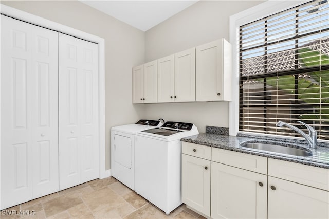 washroom featuring sink, cabinets, and independent washer and dryer