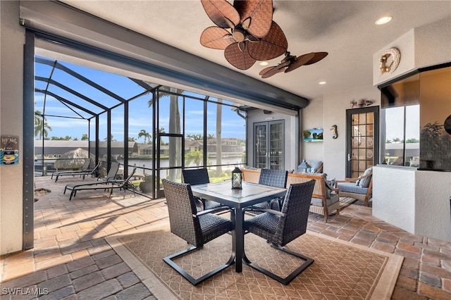 view of patio / terrace with outdoor lounge area, french doors, a water view, ceiling fan, and a lanai