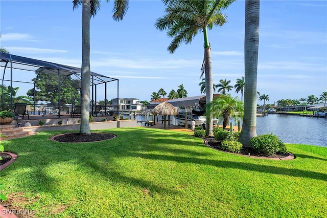 view of yard featuring a lanai, a water view, and a boat dock