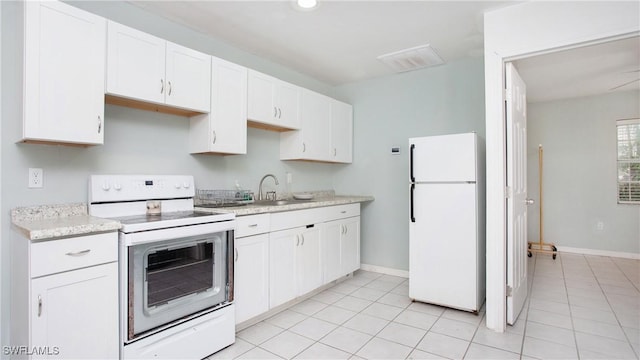 kitchen featuring white cabinetry, light tile patterned flooring, and white appliances