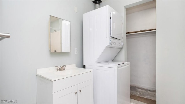 laundry area with stacked washer and clothes dryer and sink