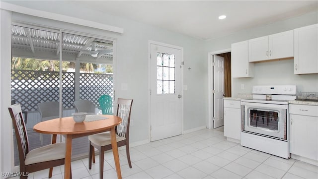 kitchen featuring electric stove, white cabinets, and light tile patterned flooring