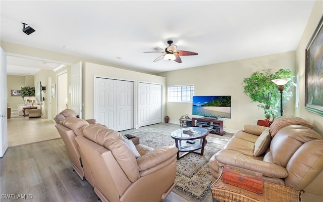 living room featuring ceiling fan and light hardwood / wood-style floors