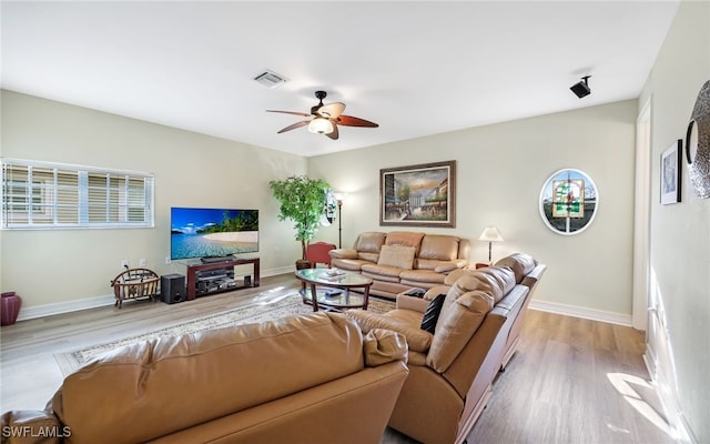 living room featuring light hardwood / wood-style flooring and ceiling fan