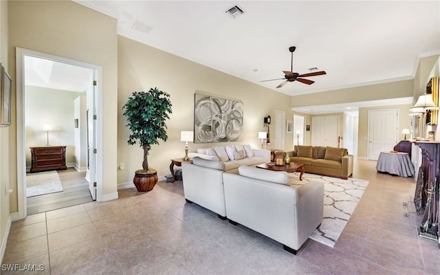 tiled living room featuring ceiling fan and ornamental molding