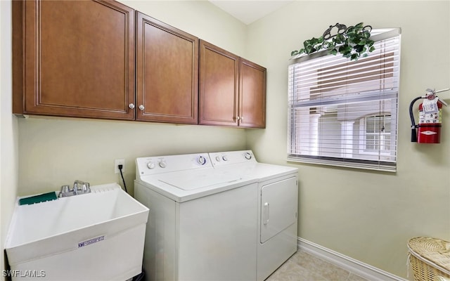 washroom featuring cabinets, sink, light tile patterned flooring, and washer and dryer