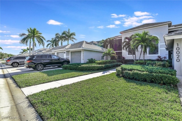 view of front of home with a front yard and a garage