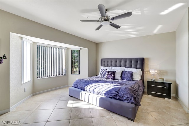 tiled bedroom featuring multiple windows and ceiling fan