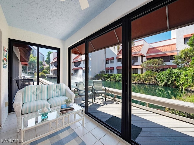 entryway featuring a textured ceiling, a water view, and light tile patterned floors