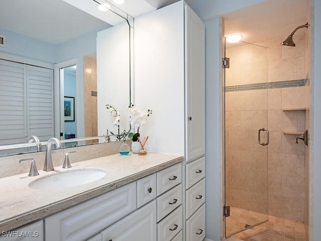 bathroom with vanity and a shower with door