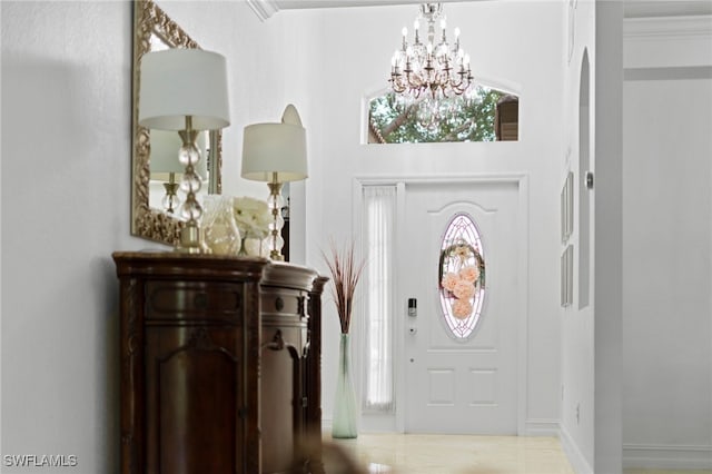 foyer featuring ornamental molding and a notable chandelier