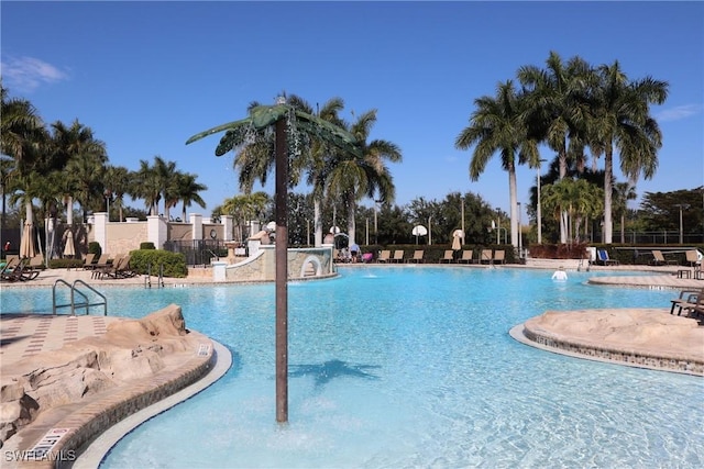 community pool with a patio area and fence