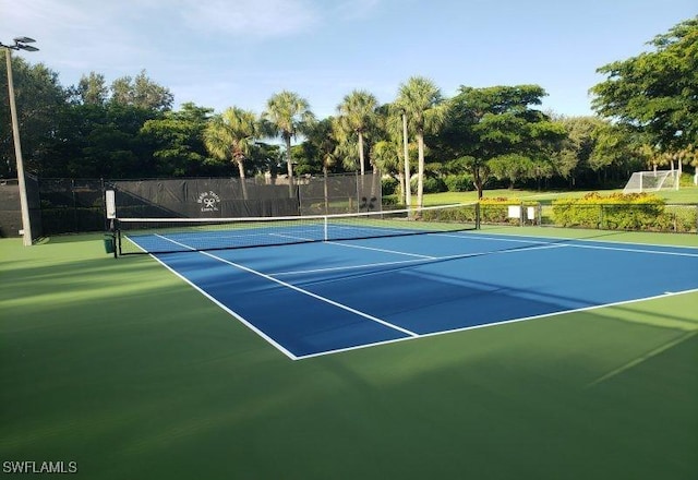 view of tennis court featuring fence