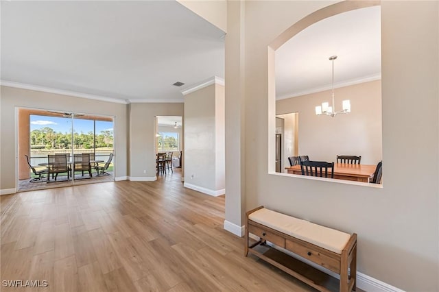 corridor featuring a chandelier, hardwood / wood-style floors, and crown molding