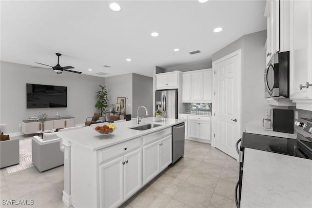 kitchen featuring sink, ceiling fan, appliances with stainless steel finishes, a kitchen island with sink, and white cabinetry