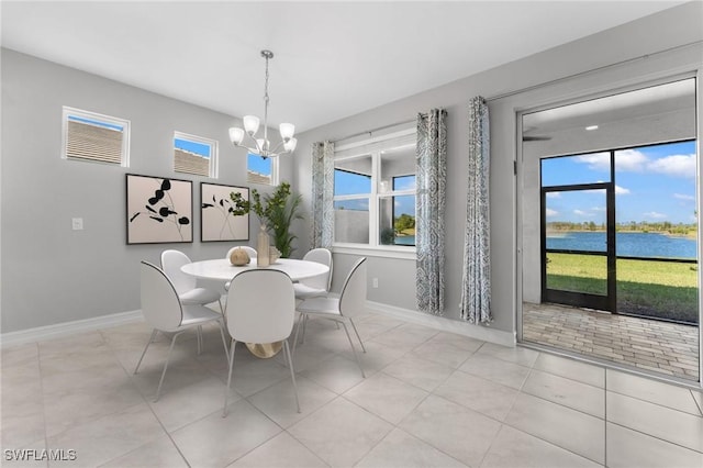 dining space with a wealth of natural light, baseboards, an inviting chandelier, and a water view