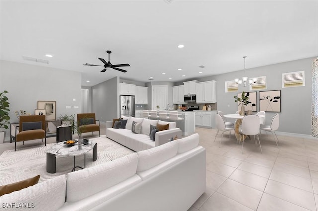 living area with visible vents, ceiling fan with notable chandelier, recessed lighting, light tile patterned flooring, and baseboards