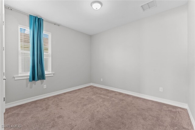 carpeted spare room with baseboards and visible vents