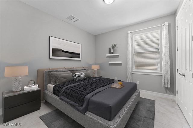 bedroom with light tile patterned flooring, visible vents, and baseboards