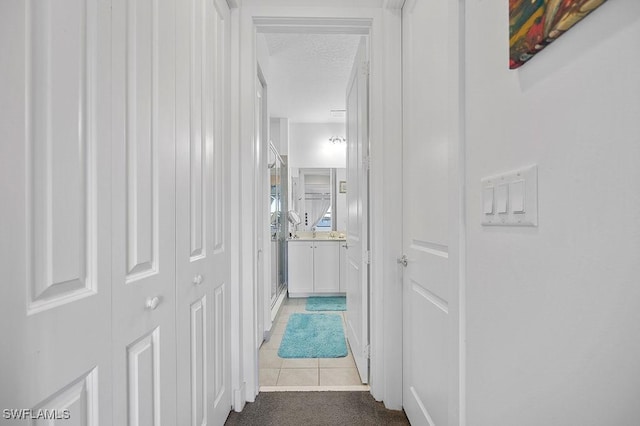 hallway featuring tile patterned floors and a textured ceiling