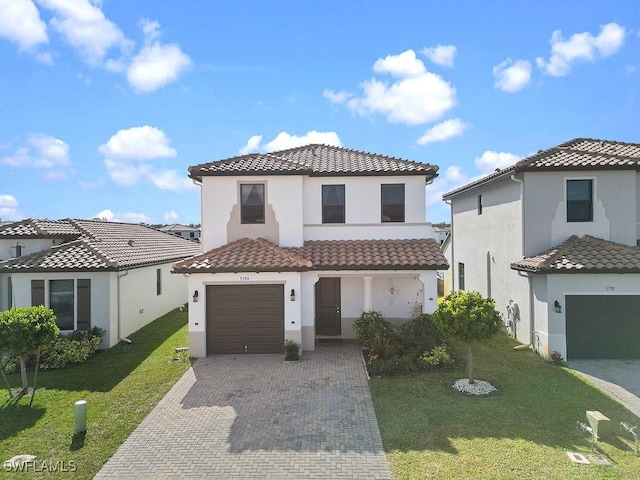 mediterranean / spanish home featuring a front yard and a garage