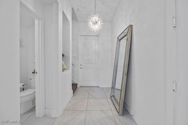 hallway with an inviting chandelier