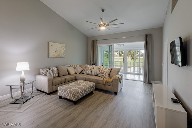 living room with ceiling fan, light hardwood / wood-style floors, and vaulted ceiling