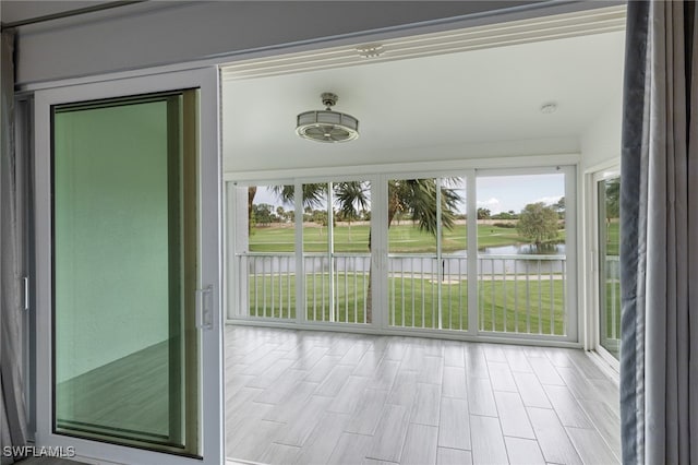 unfurnished sunroom featuring plenty of natural light and a water view