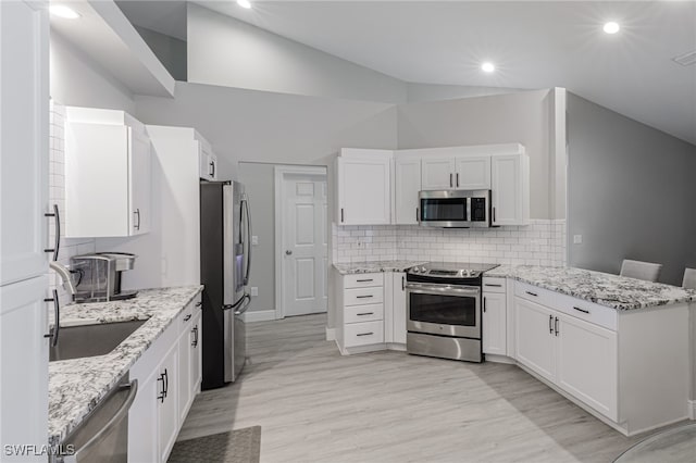 kitchen with white cabinetry, high vaulted ceiling, light wood-type flooring, and appliances with stainless steel finishes