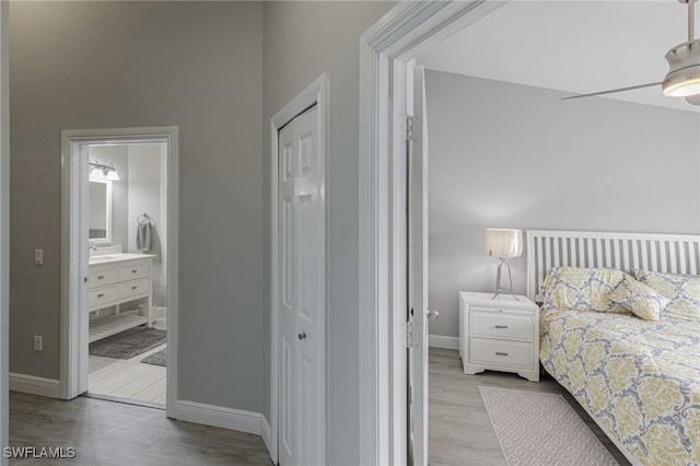 bedroom with ceiling fan, a closet, connected bathroom, and light hardwood / wood-style flooring