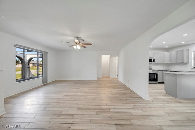 unfurnished living room with light hardwood / wood-style floors and ceiling fan