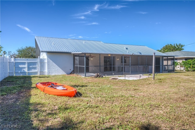 back of house featuring a lawn and a sunroom