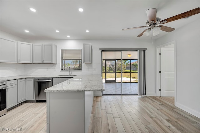 kitchen featuring light stone countertops, light hardwood / wood-style floors, and sink