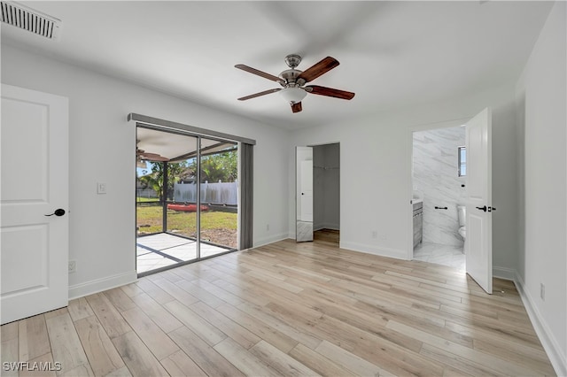 unfurnished bedroom with connected bathroom, access to exterior, ceiling fan, a closet, and light wood-type flooring