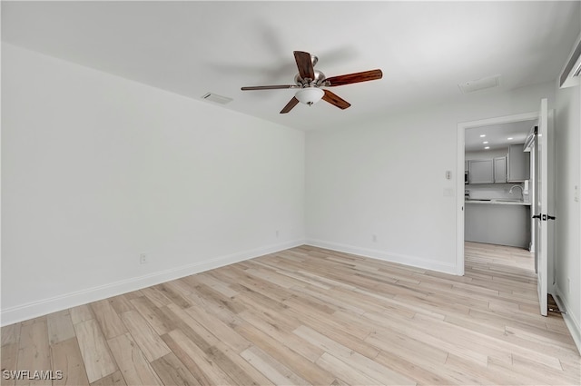 unfurnished room featuring light wood-type flooring, ceiling fan, and sink