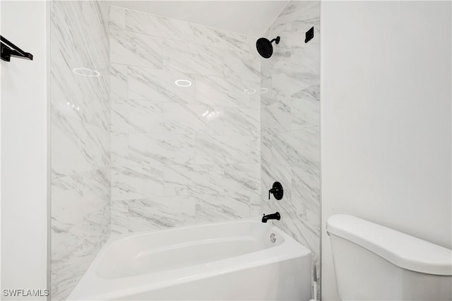 bathroom featuring toilet and tiled shower / bath