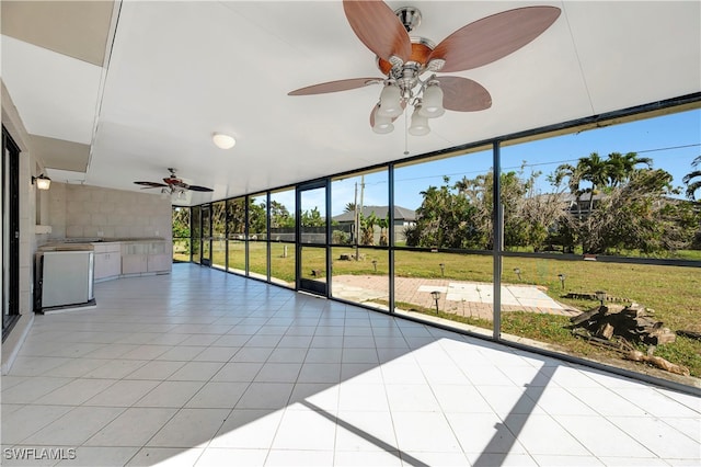 unfurnished sunroom with ceiling fan