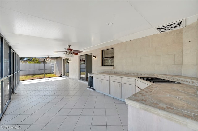 kitchen with floor to ceiling windows, wine cooler, ceiling fan, gas stovetop, and light tile patterned floors