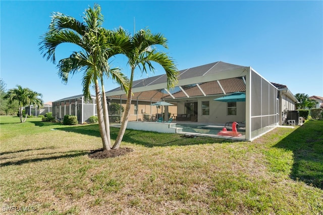 back of house with a lawn, glass enclosure, and a patio area