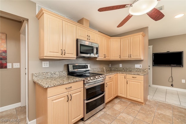 kitchen with light stone countertops, stainless steel appliances, ceiling fan, light tile patterned floors, and light brown cabinets