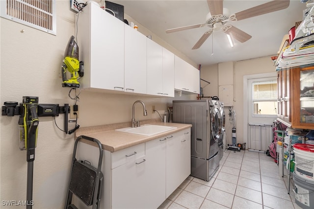 washroom featuring cabinets, ceiling fan, sink, light tile patterned floors, and independent washer and dryer