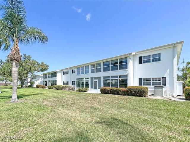 back of property with a lawn and central AC unit