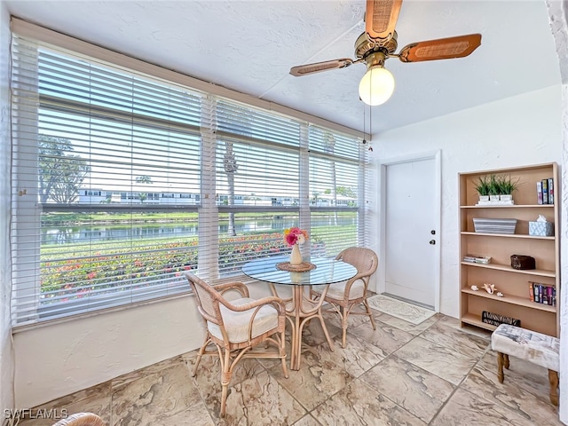 dining space with ceiling fan and a textured ceiling