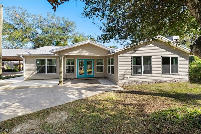 back of house with a lawn and french doors