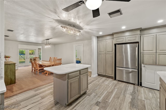 kitchen featuring decorative light fixtures, light hardwood / wood-style floors, stainless steel refrigerator, and french doors