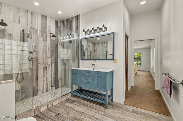 bathroom featuring vanity, wood-type flooring, and tiled shower