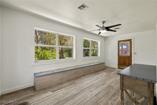 unfurnished dining area featuring ceiling fan and light wood-type flooring