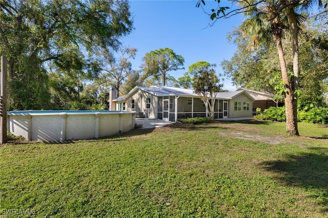 back of house with a sunroom and a lawn