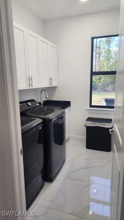 washroom featuring cabinets, sink, and washing machine and clothes dryer