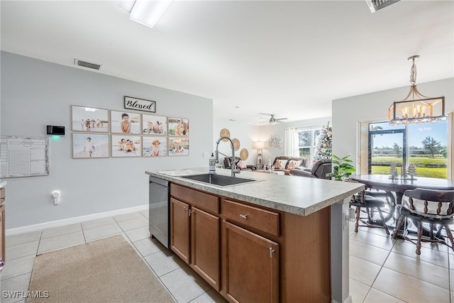 kitchen featuring a kitchen island with sink, ceiling fan with notable chandelier, sink, hanging light fixtures, and stainless steel dishwasher